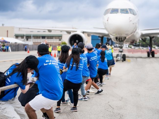 Group of people pulling a plane  