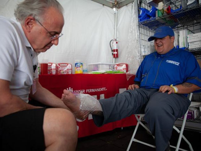 A physician treats an athlete's injured ankle using ice therapy
