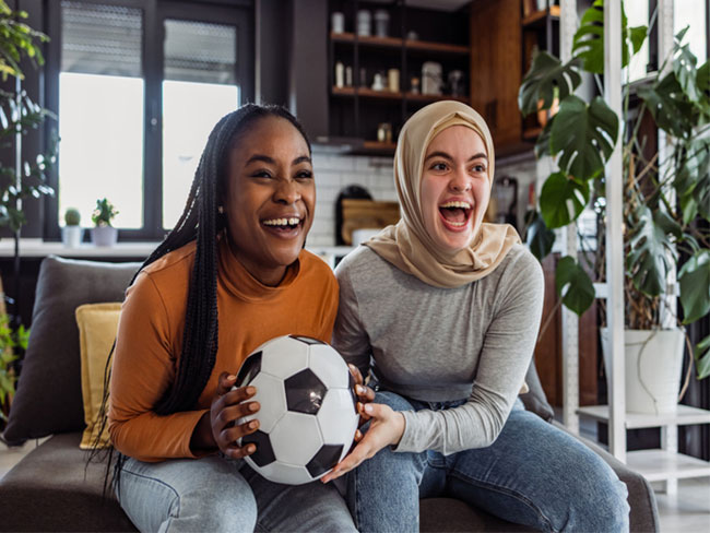 2 young women holding a soccer ball