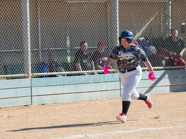 A Special Olympics athlete runs during a softball match.