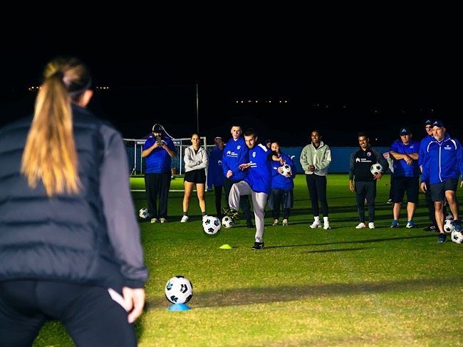 Athletes practicing soccer drills with Naomi Girma.