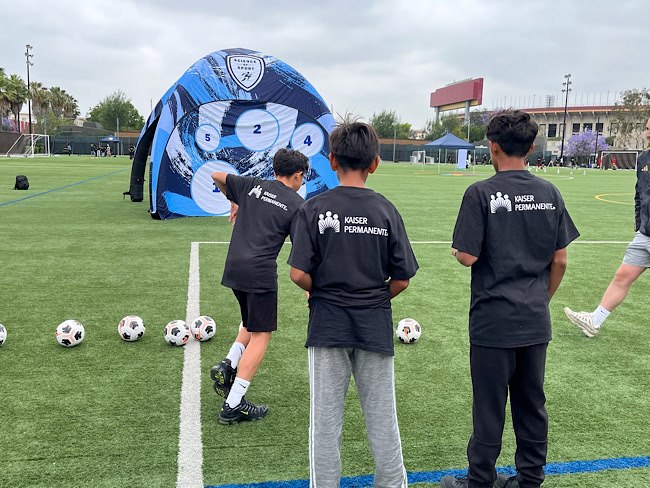 3 boys running soccer drills at an LAFC Fit field trip.