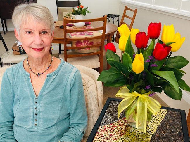 Virginia Heerema seated next to a vase with tulips