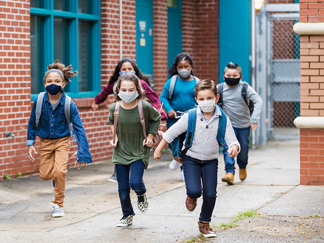 school-aged children wearing face masks outdoors