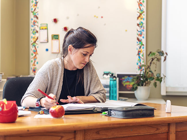A school employee looks over paperwork at desk