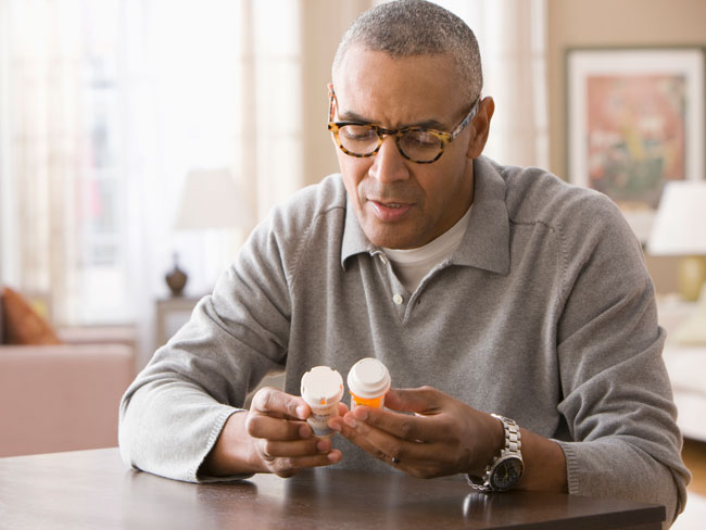 senior man examining his prescription medicine bottles