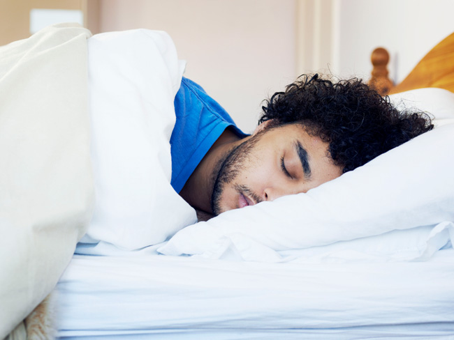 man in bed sleeping on his side