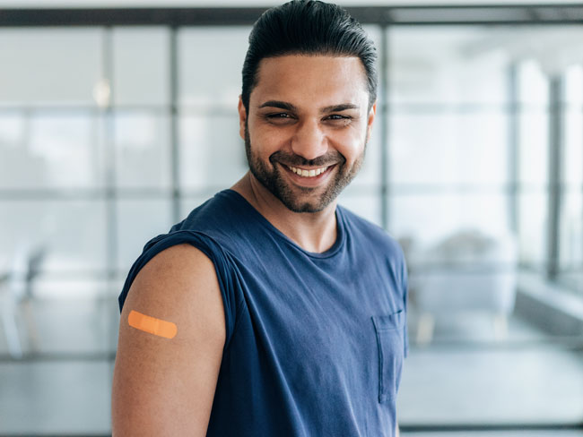 smiling man with band-aid on arm