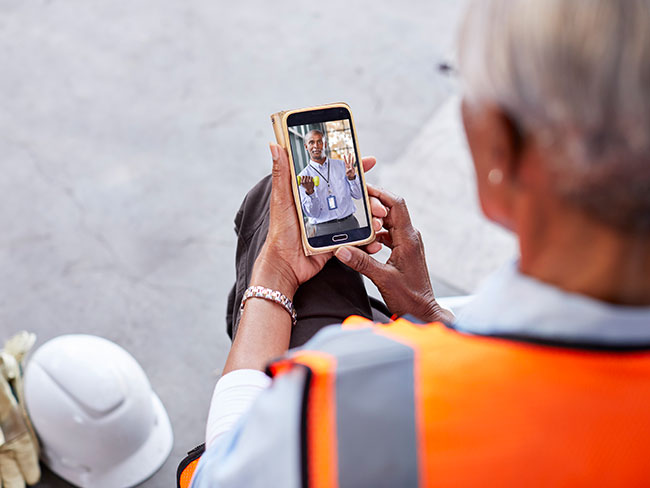 female construction worker on a mobile phone with her physician during a telehealth visit