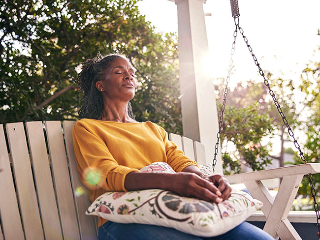 Woman relaxing on porch swing.