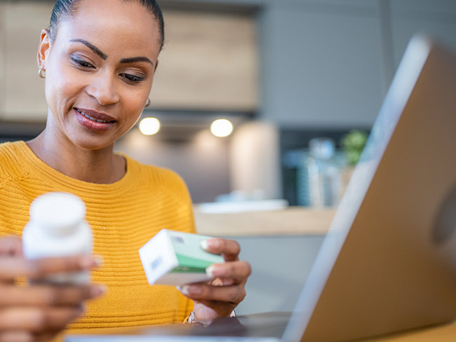 Woman reviewing her prescription medications at a table.