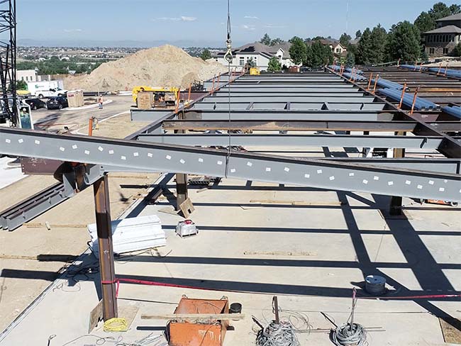 Beam being placed on steel structure.