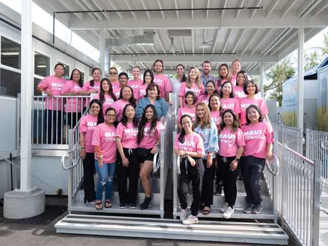 Lahaina clinic staff in pink shirts on stairs