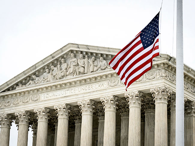 The Supreme Court building, with the U.S. flag waving in front.