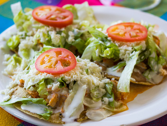 Tostadas with turkey, lettuce, and tomato.