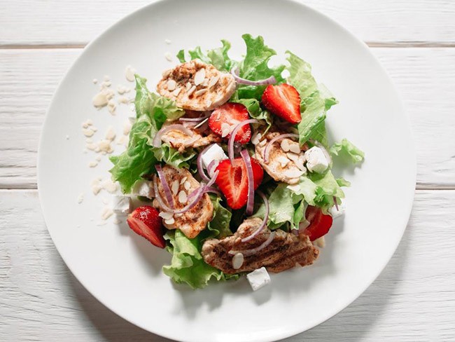 Summer salad with strawberries, chicken, walnuts, and feta