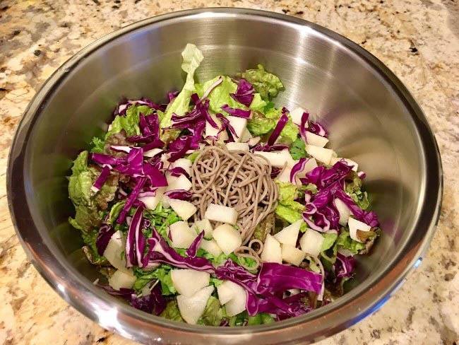Salad with lettuce, red cabbage, diced asian pears and soba noodles.