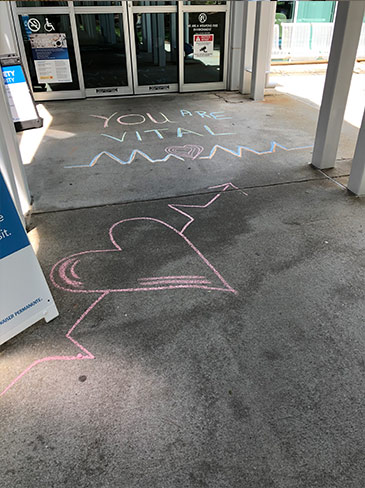 You are vital written in chalk outside a hospital entrance
