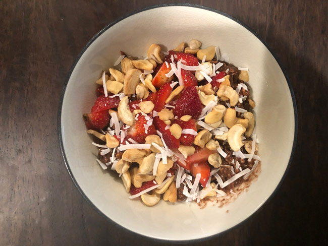 Overnight chocolate oats, topped with strawberries, cashews, and coconut flakes