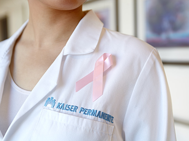 pink ribbon pinned onto the white coat of a Kaiser Permanente physician