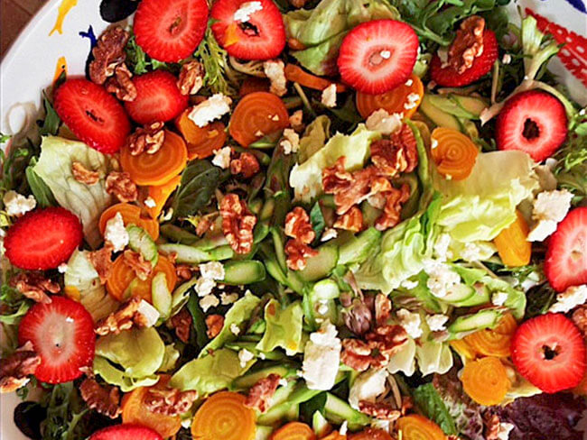 Early spring salad with sliced strawberries and almonds with cheese
