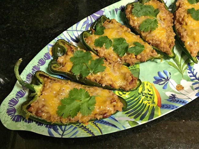 Easy refried bean poblanos with cheese arranged on a serving dish. 