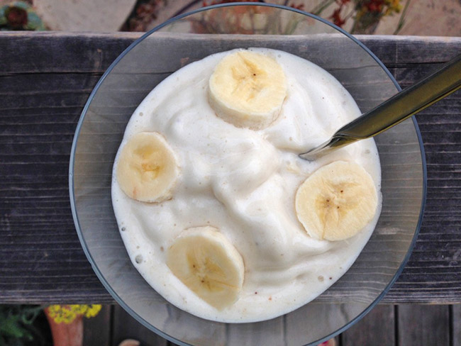 Bowl of puréed banana dessert garnished with 4 round banana slices