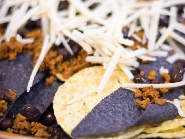 tortilla chips with shredded cheese and vegetarian toppings