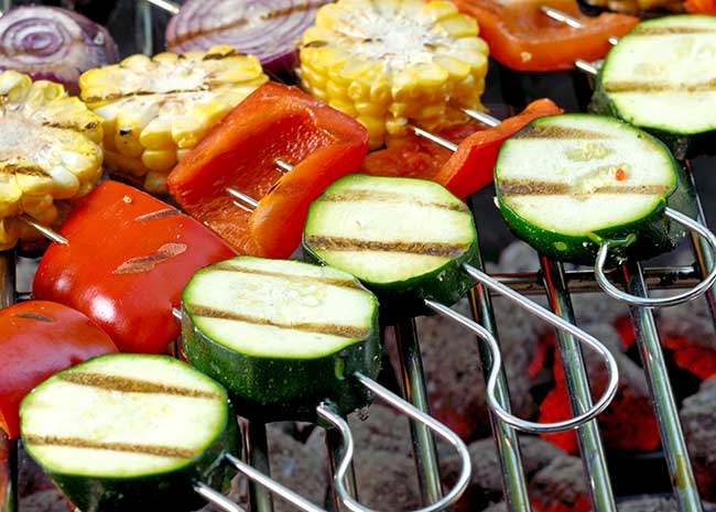 Vegetables on skewers on a hot grill.