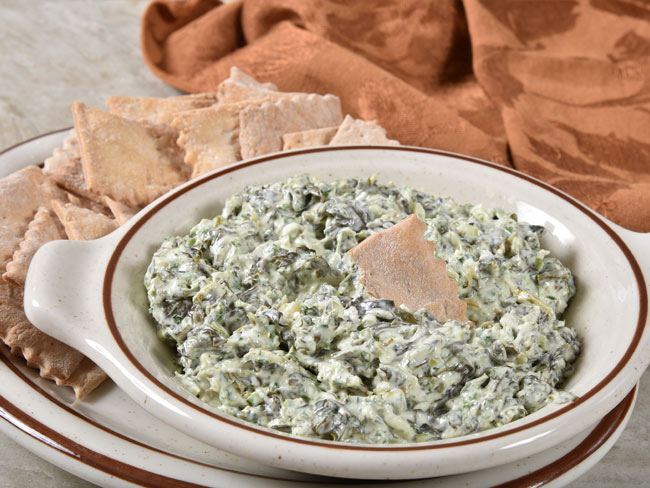 Kale dip with garlic and cheese, and pita chip dipped in middle