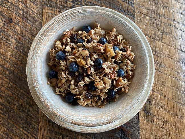 Bowl of oats mixed with blueberries and nuts.