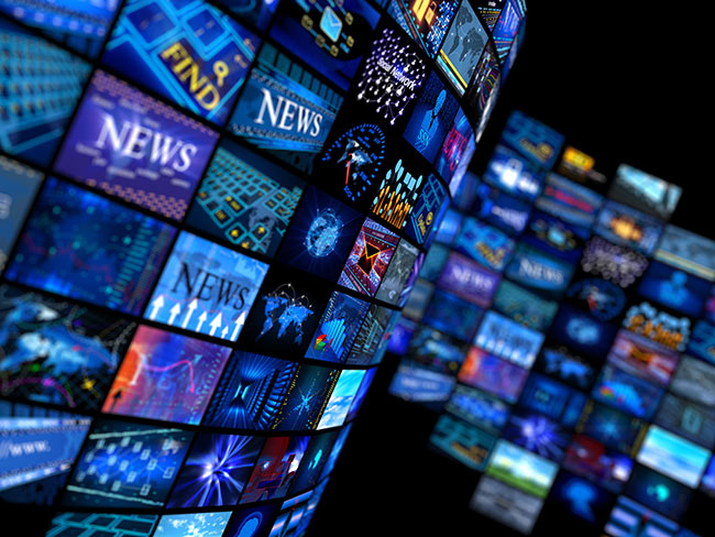 Multiple television screens playing news programs
