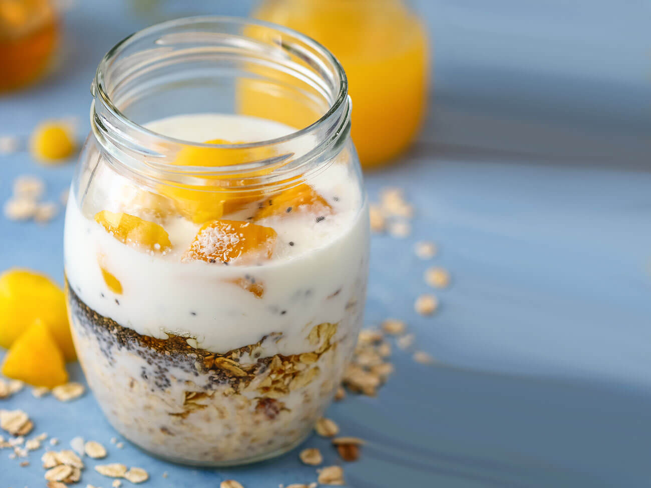 Rolled oats mixed with honey and milk topped with mango in a mason jar