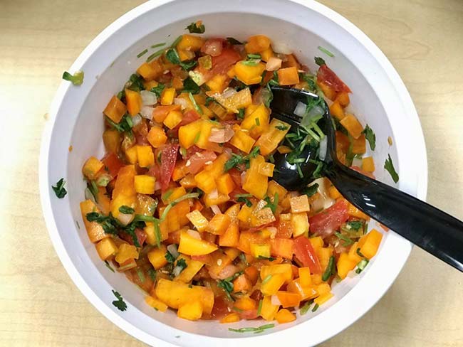 Bowl of persimmon salsa with serving spoon
