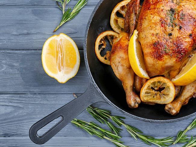 Roasted chicken with lemon in a pan. 