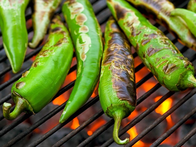 Anaheim peppers roasting on a hot grill.
