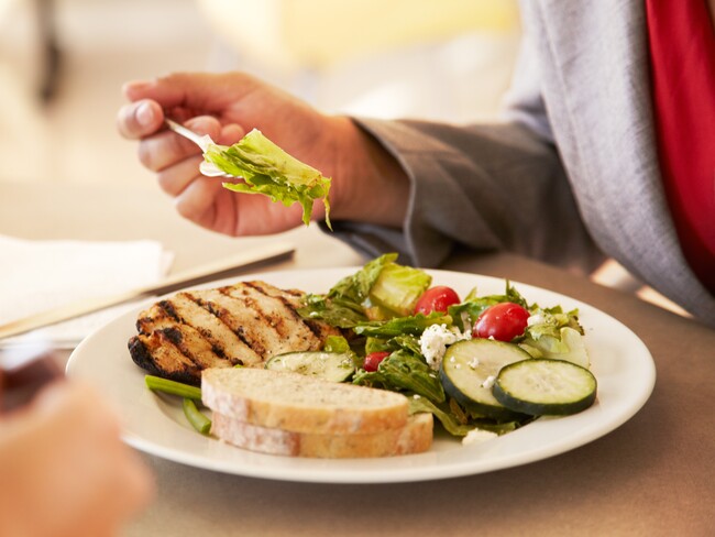 Plate of grilled chicken, salad, and bread