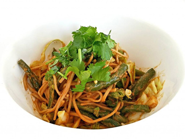 Thai peanut noodles garnished with cilantro served in a white bowl