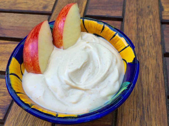 bowl of blended tofu peanut butter dip and apple slices