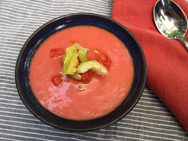 Watermelon and tomato gazpacho, garnished with chopped celery and diced tomatoes. 